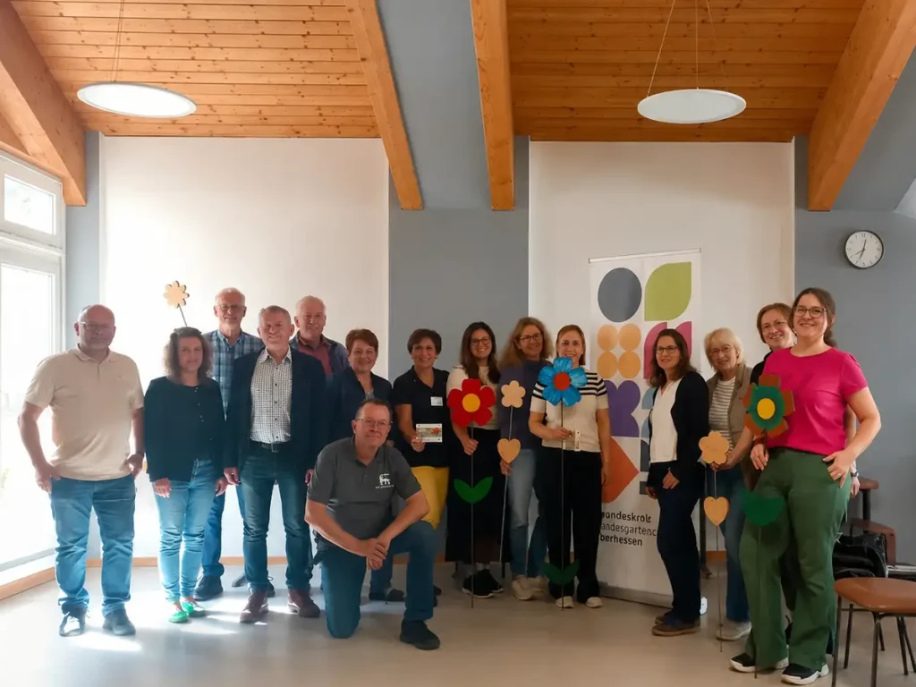 Teilnehmende der Mitmachaktion „Bunte Blumen für kleine Künstler*innen“ präsentieren Holzblumen im Rahmen der Landesgartenschau Oberhessen 2027