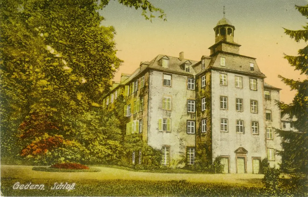 Kolorierte historische Darstellung eines mehrstöckigen Schlosses mit Turm, umgeben von Bäumen und einer gepflegten Grünanlage.