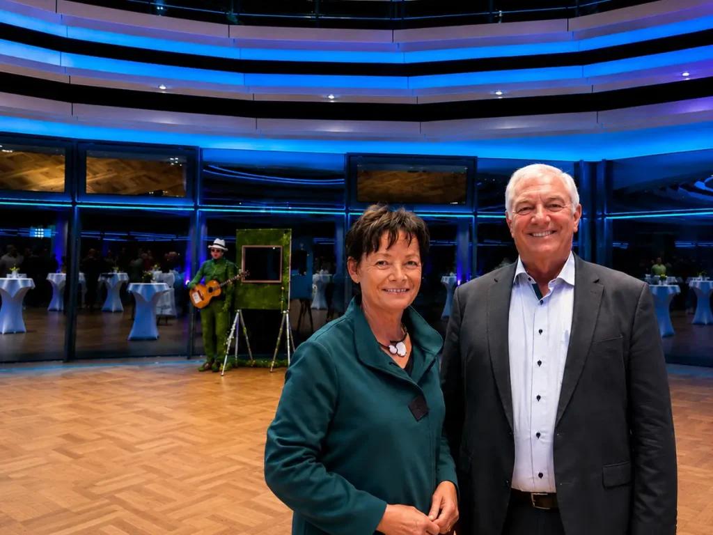Lucia Puttrich und ihr Mann Hagen bei einer festlichen Abendveranstaltung in modern beleuchteter Location mit blau-violetter Lichtstimmung.