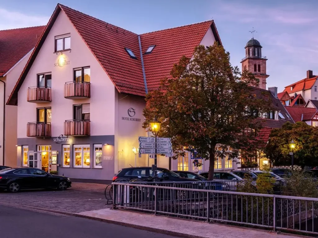 Außenansicht des Romantik Hotels Schubert in Lauterbach mit historischer Altstadtkulisse in der Abenddämmerung