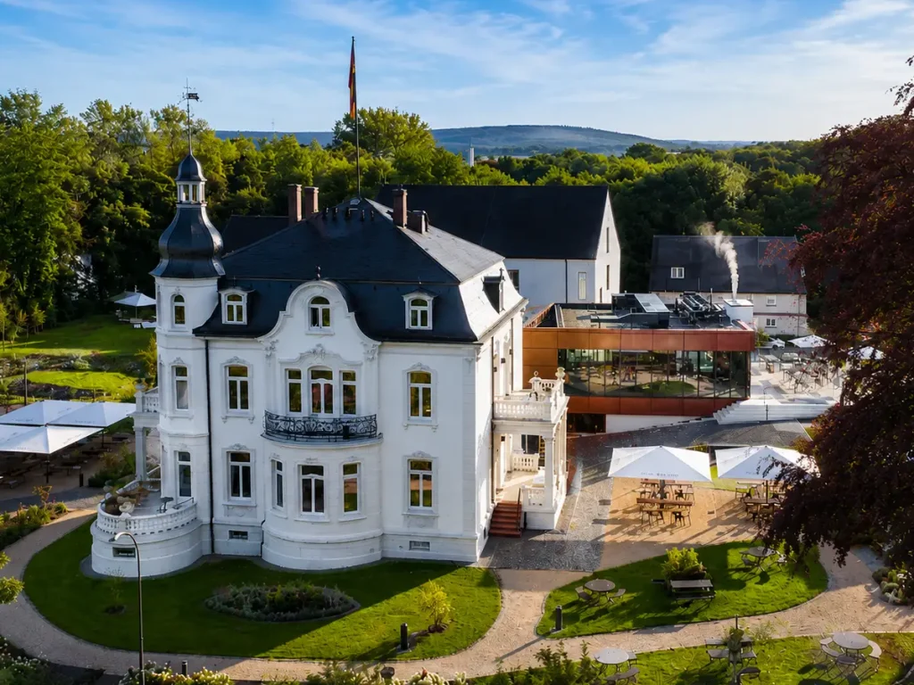 Luftaufnahme der Villa Raab in Alsfeld mit historischer Jugendstilvilla, modernem Anbau, Terrasse und Parkanlage.