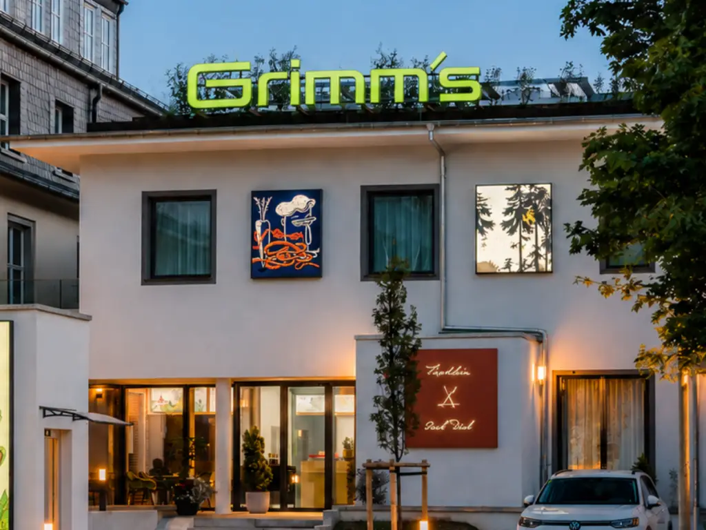 Außenansicht des Grimm’s Hotel Hanau mit modernem Eingangsbereich und markantem Hotel-Schriftzug