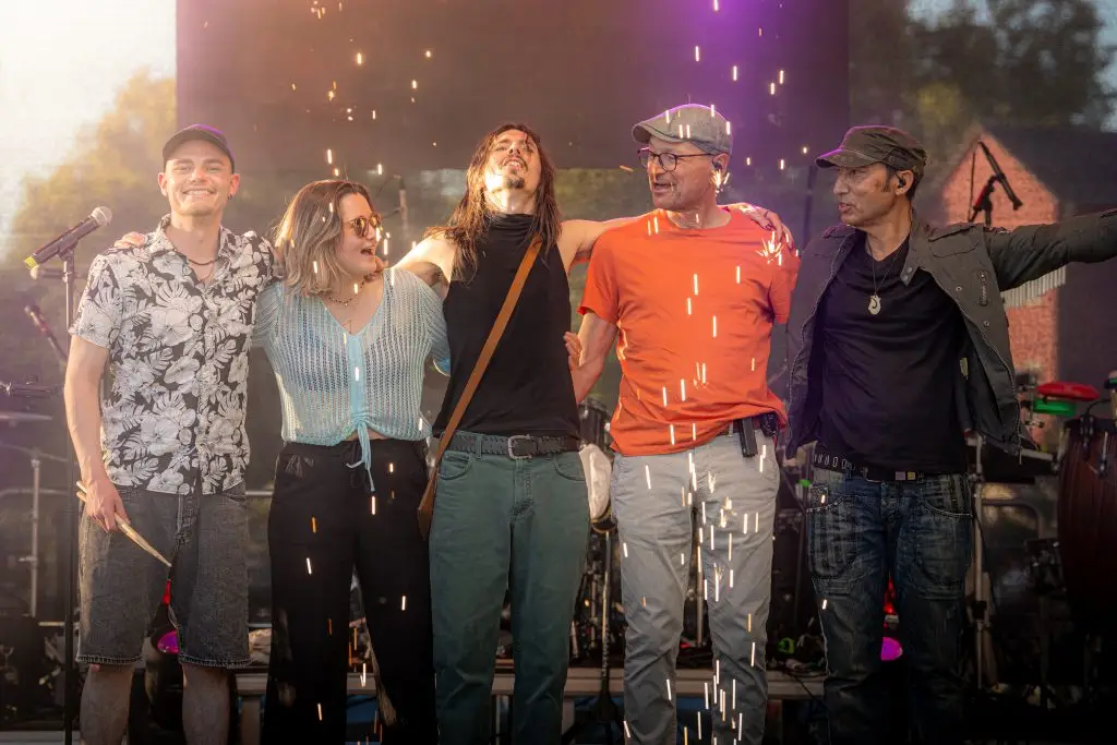 Die fünf Mitglieder der Band LEO stehen Arm in Arm auf einer Bühne. Funkenregen, Bühnenlicht und lächelnde Gesichter vermitteln die Stimmung eines gefeierten Live-Konzerts.