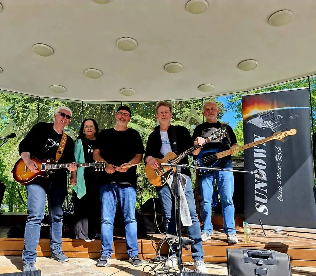 Die Band Sundown steht mit Gitarren und Bass auf einer kleinen Außenbühne.