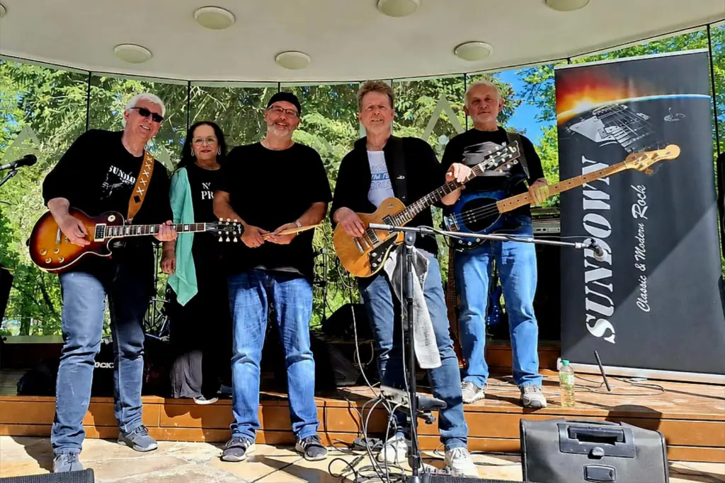 Die Band Sundown steht mit Gitarren und Bass auf einer kleinen Außenbühne.