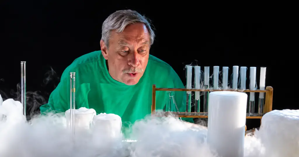 Christoph Biemann führt ein Experiment mit Reagenzgläsern und aufsteigendem weißen Nebel vor.